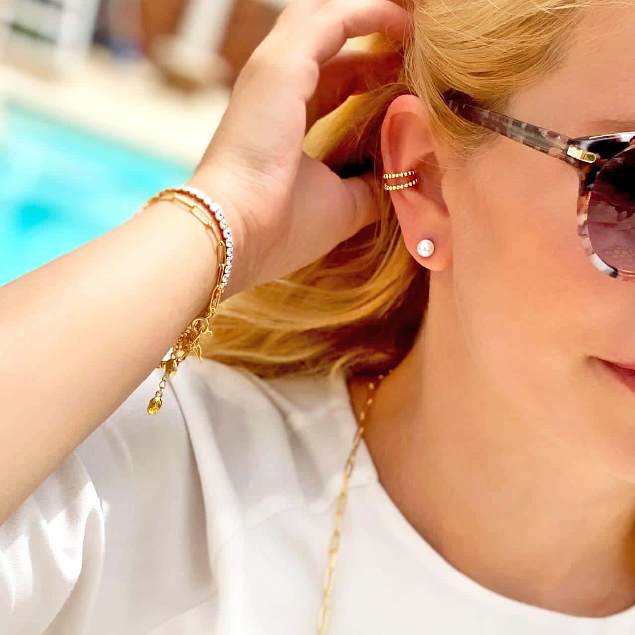 Trendige Ear Cuffs aus 18 Karat vergoldetem Silber zu weiteren Schmuckstücken gestylt am Pool Grand Resort in Bad Ragaz