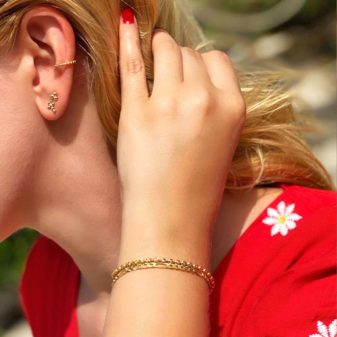 Feine goldene Armbänder und passender Ohrschmuck im Parco Ciani in Lugano Feine Armbänder und viele Ohrringe aus Sterling Silber 925 von blonder Frau im Parco Ciani un Lugano geragen