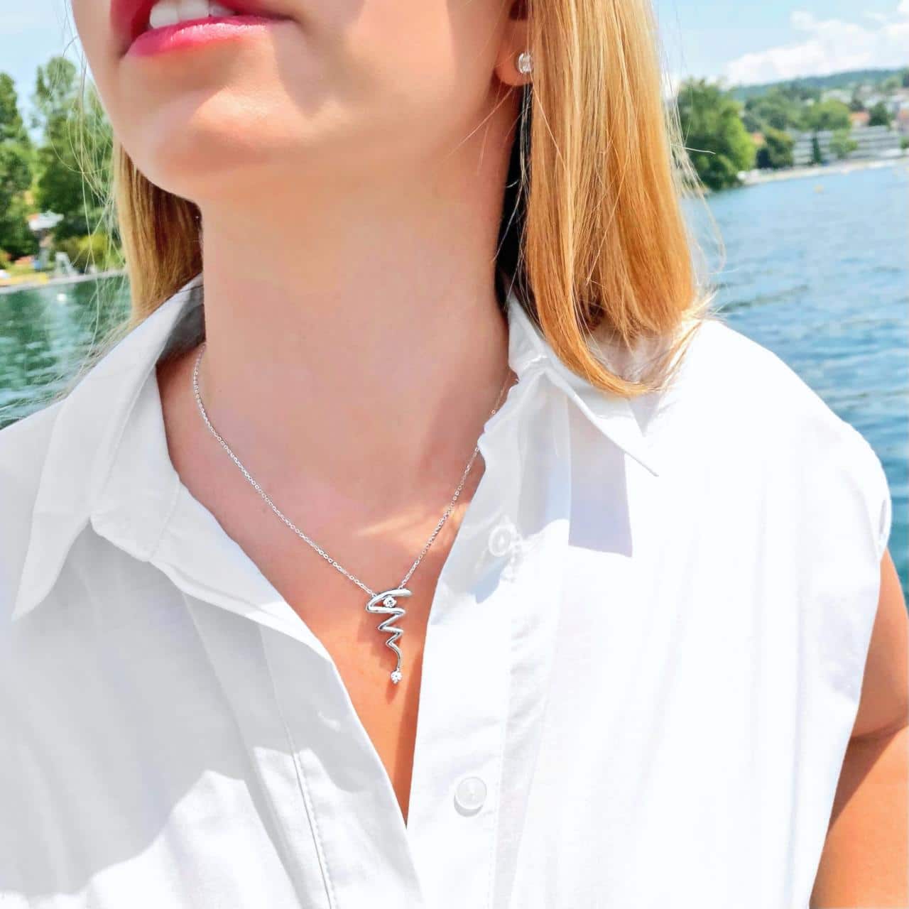 Anker-Halskette mit ausgefallenem Anhänger  beides aus Sterling Silber rhodiniertzum weissen Blusenkleid getragen vor Eden Au Lac in Zürich 