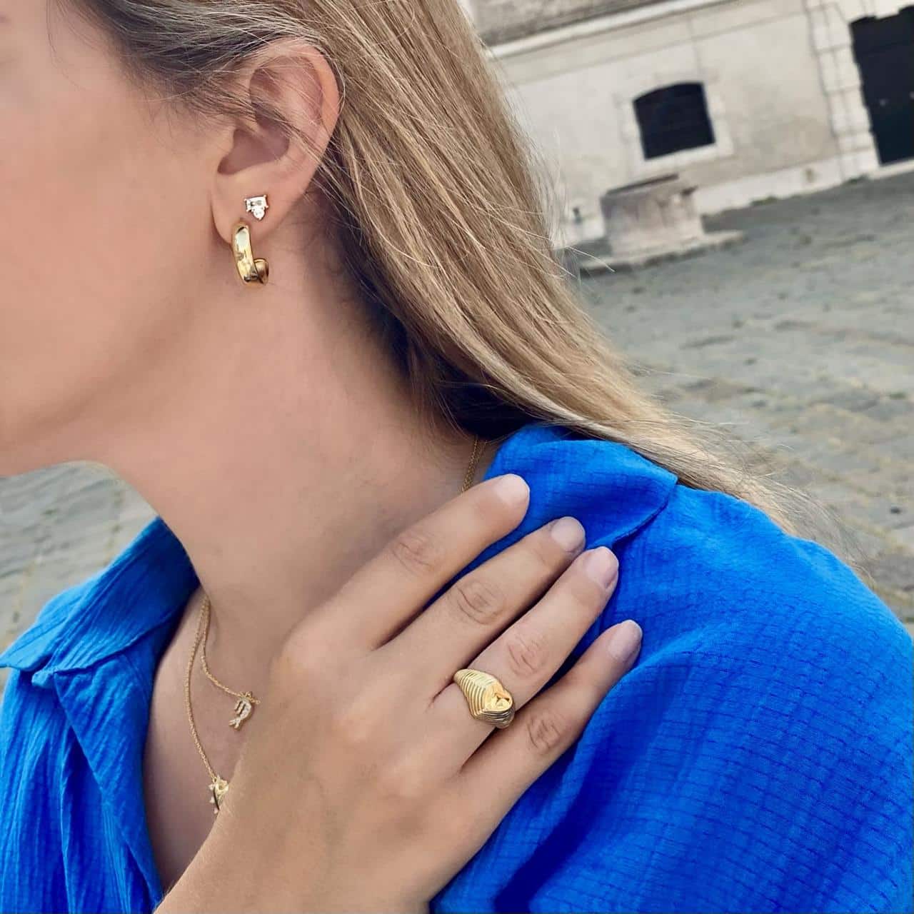 Model mit blauem Kleid trägt auffälligen Goldschmuck bei Löwendenkmal in Luzern 