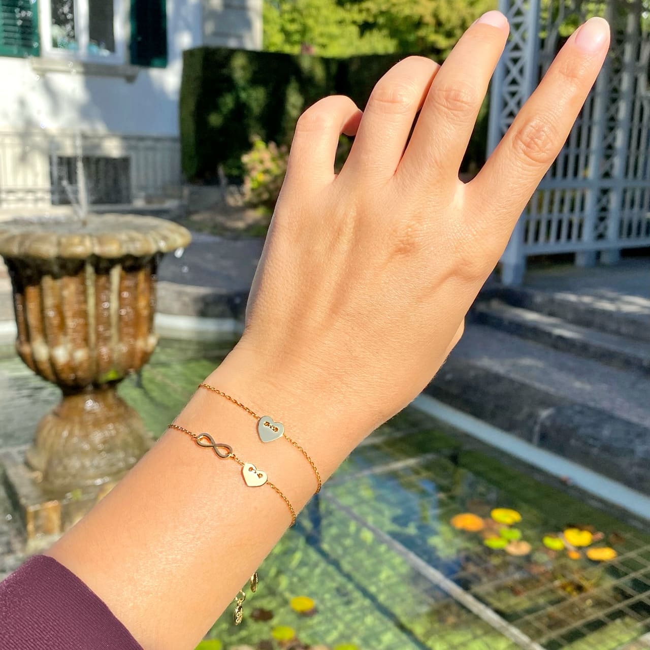 Infinity-Armband und Herz-Armband aus 18 Karat vergoldetem Sterling Silber zusammen getragen in Baden