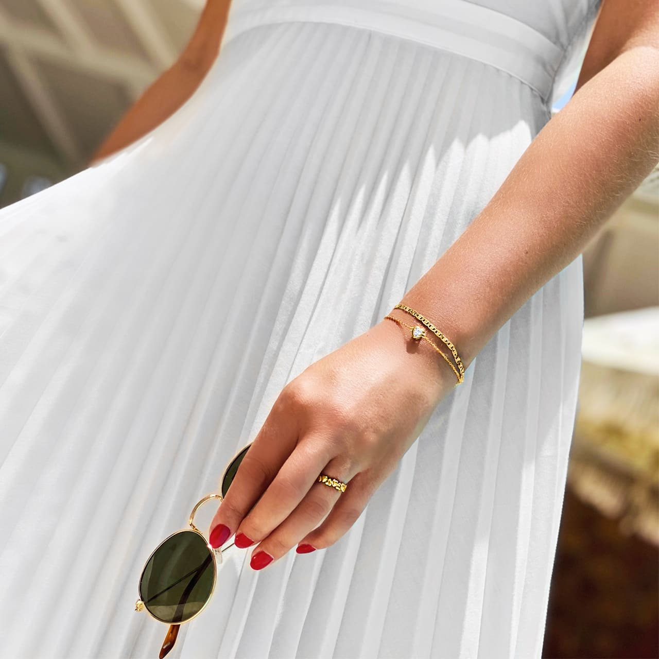 Goldschmuck und weisses Kleid auf der Terrasse des Luxus Hotel Vitzenau