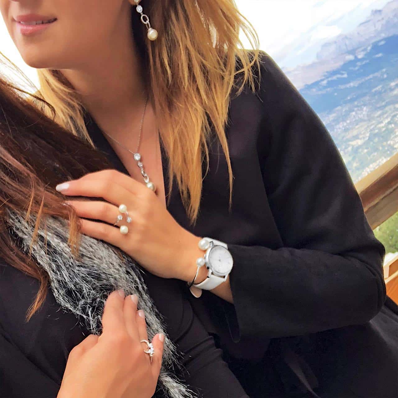Silberschmuck mit Perlen und weisse Armbanduhr von brünetter Frau auf dem Tittlis