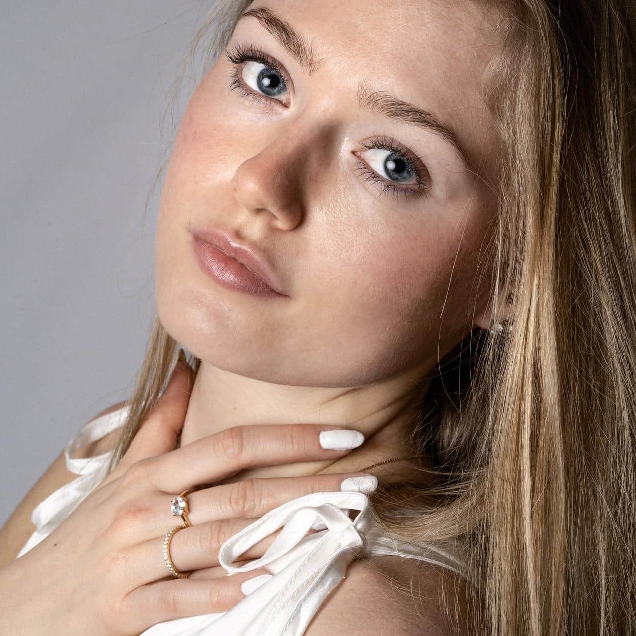 Blondes Model trägt Ring aus vergoldetem Silber mit ovalen Stein zu weissem Outfit für Shooting in Bern