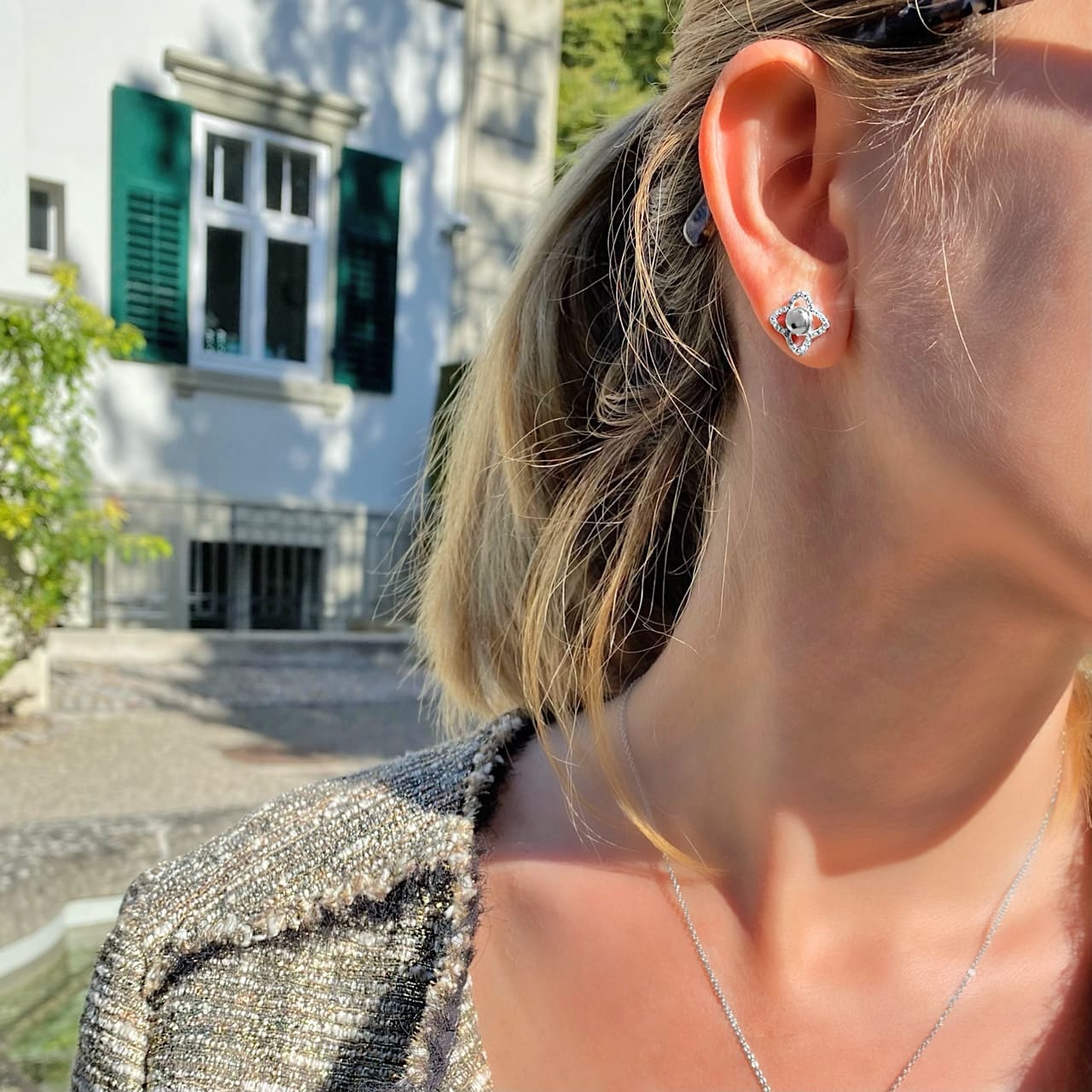 Frau trägt Ohrringe aus Sterling Silber 925 mit funkelnden Steinen in Genf
