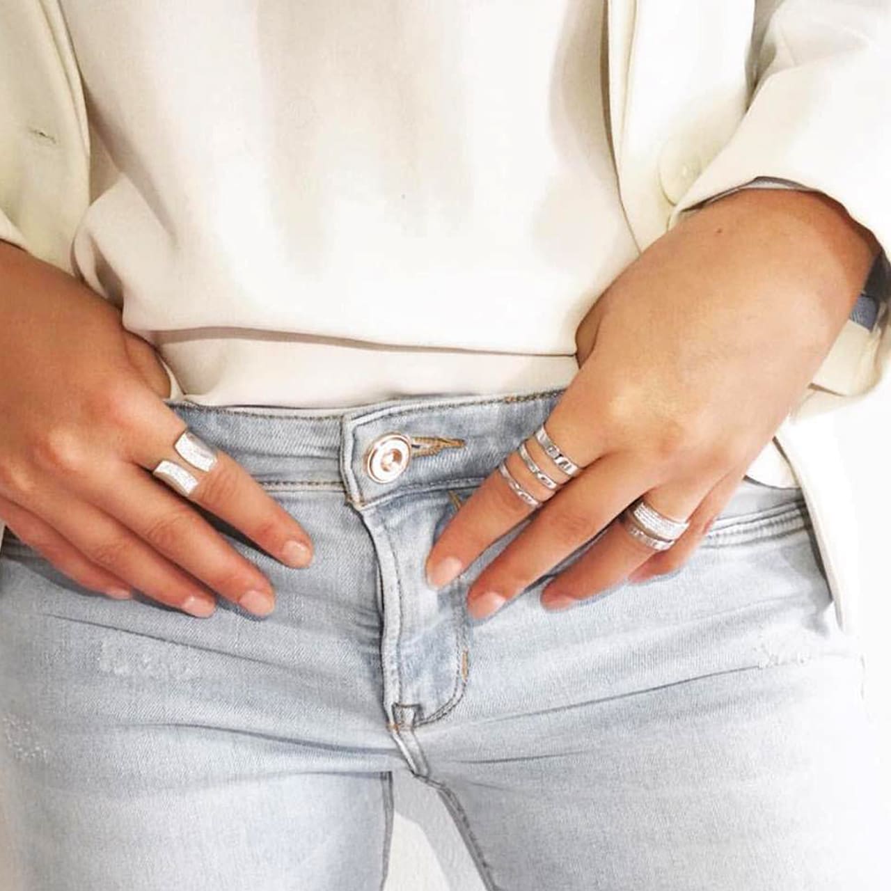 Breite Silberringe mit polierter Oberfläche und Zirkonia zu modischem Outfit mit weissem Blazer und Jeans gestylt