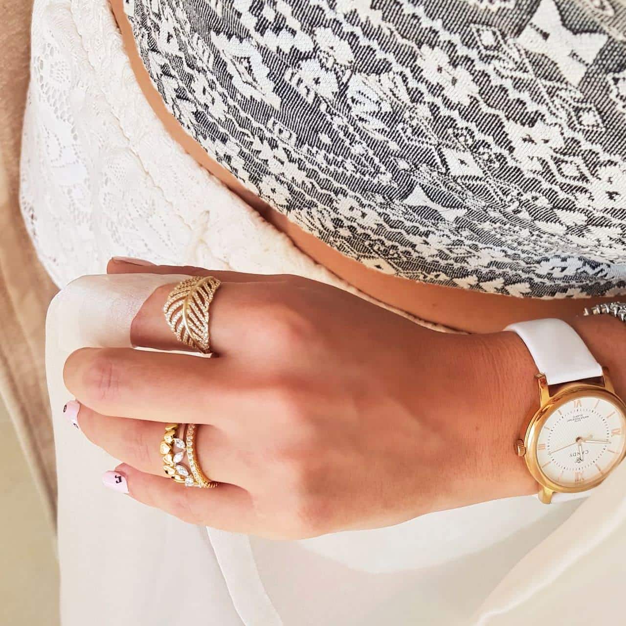 Goldene Edelstahluhr mit weissem Lederband in puren Design sommerlich kombiniert mit goldenen Ringen aus Silber
