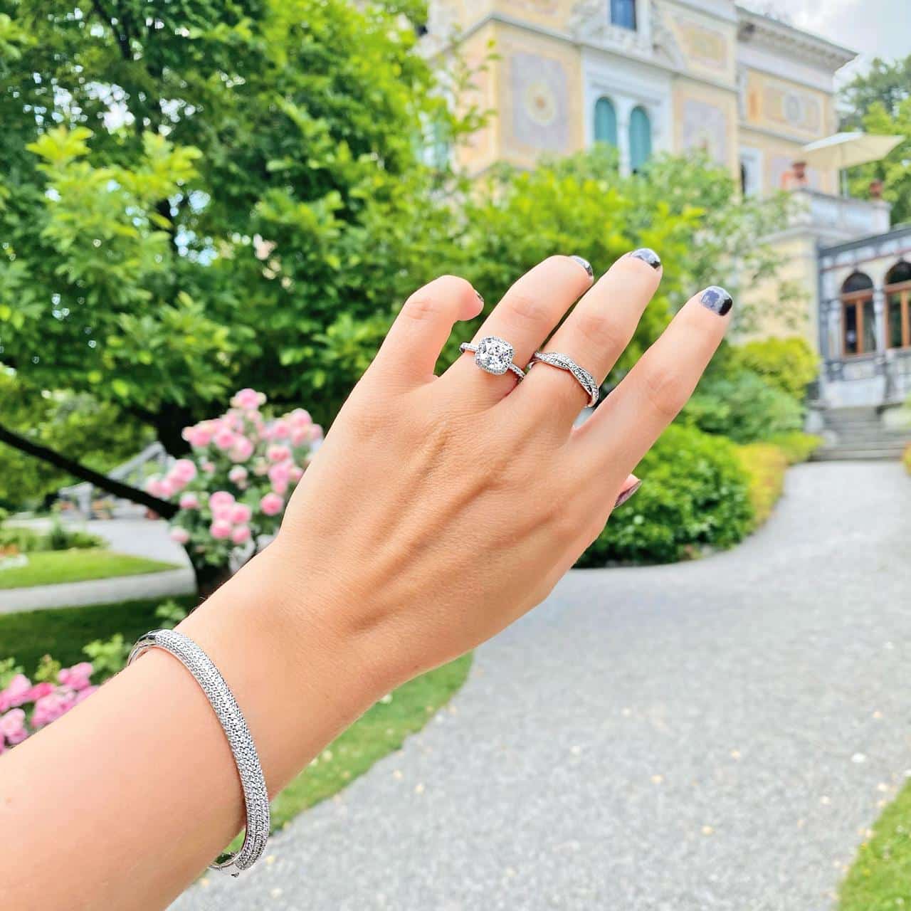 Hand mit mehreren Ringen und dunkelrotem Nagellack imPark der Villa Patumbah