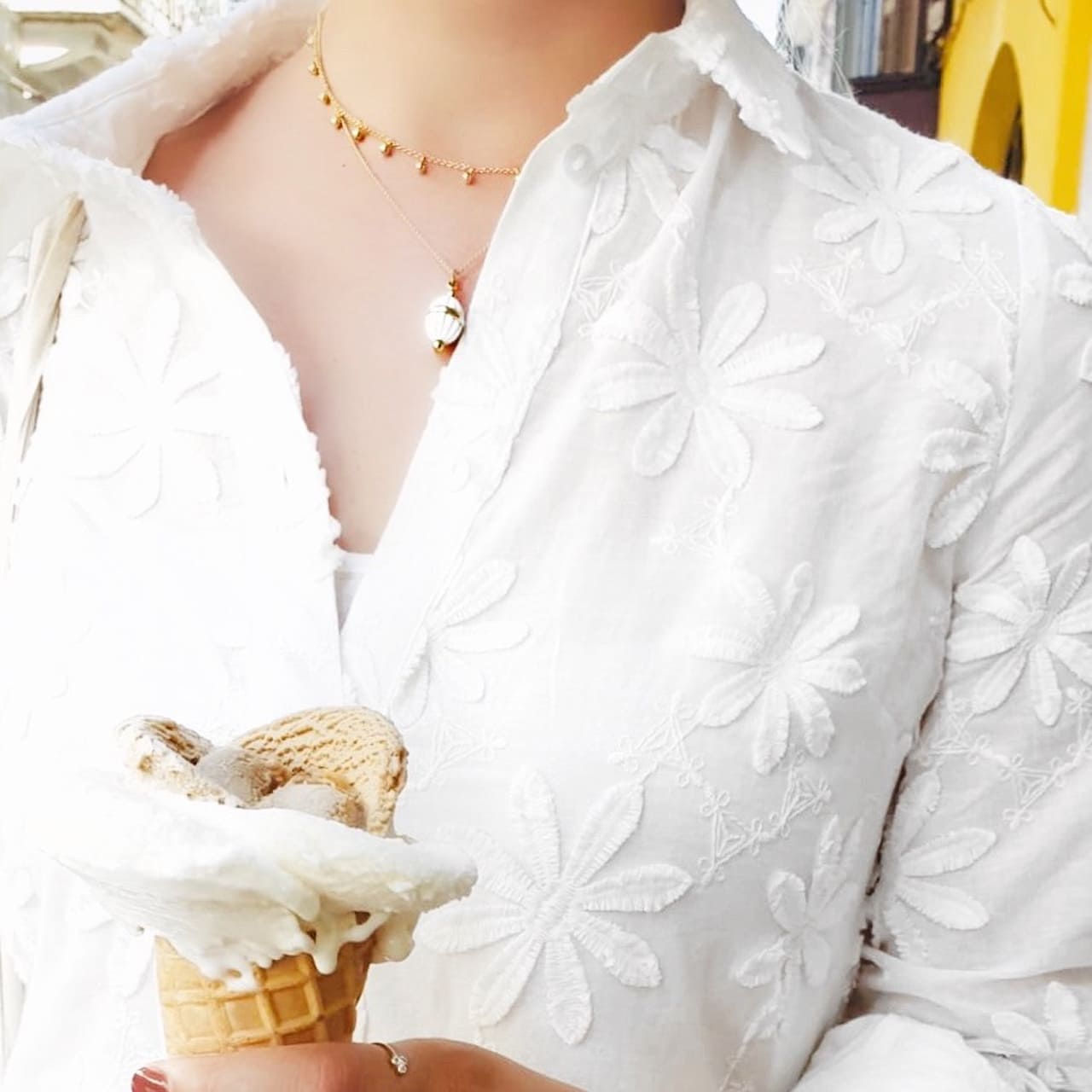 Goldene Halskette mit kleinen Kügelchen gestlyt zum weissen Kleid im Niederdorf Zürich