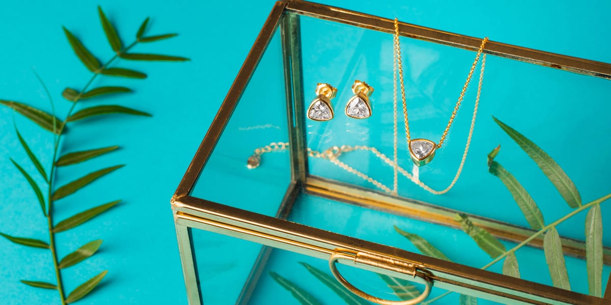 Gold plated silver jewellery set in triangle shape on a jewellery box